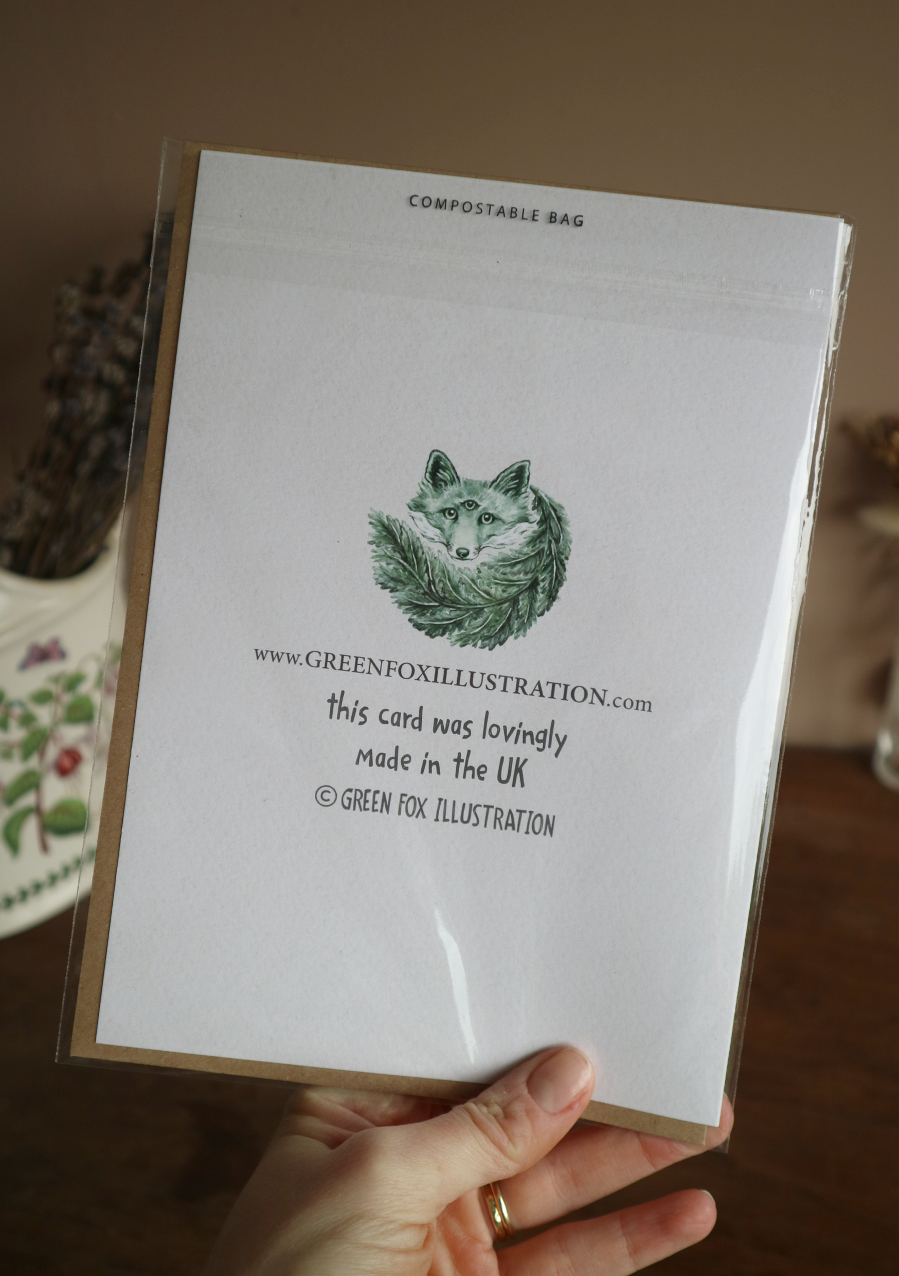 the back of a green fox illustration greetings card in sleeve